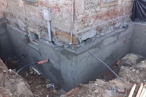 Das Ausschalen sollte am Folgetag vorgenommen werden - außer natürlich bei tragenden Elementen! Deutlich sichtbar ist die mit einem Schutzrohr versehene Wasserhauptleitung. Sogenannte "Nester" entstehen, wenn der Beton nicht genug verdichtet wurde.